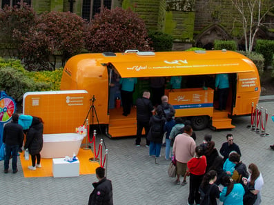 A crowd gathers at a promotional Airstream trailer for QV Skincare's experiential campaign.