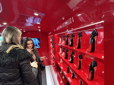 Two girls enjoy a perfume display inside Carolina Herrera's Airstream.