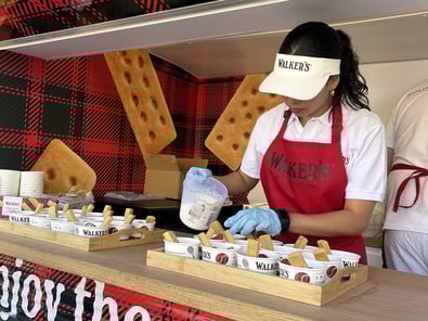 A staff member pours cream on Walker's shortbread fingers for their food and beverage campaign.