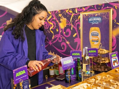 A brand ambassador serves drinks inside the Asda and Coronation promotional bus hire.