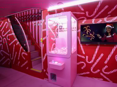 The claw machine, in pink, stands ready for Christmas gamification at a live event or campaign.