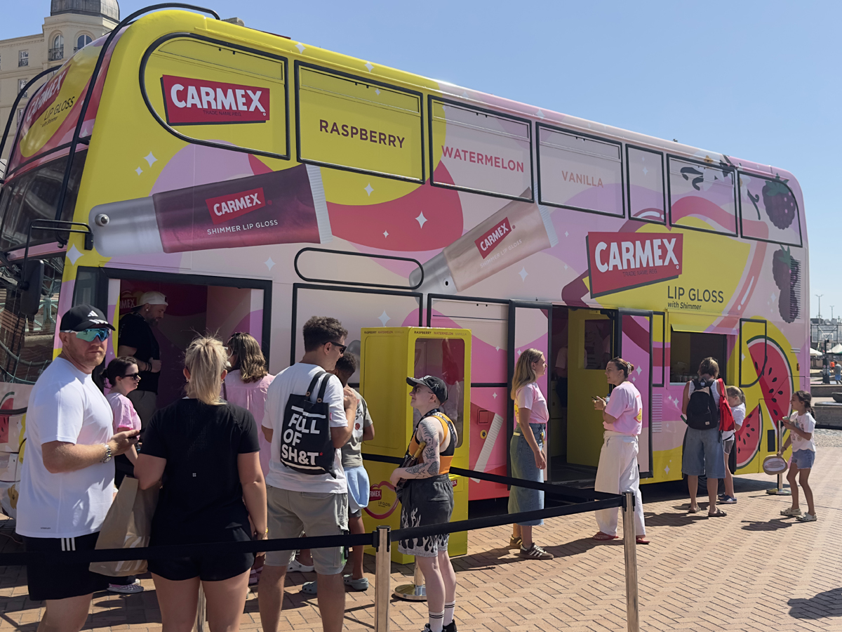 A crowd lines up for the Carmex double-decker bus immersive experience, wrapped and built by the Promohire team.