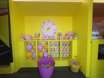 The spin game and product display inside the Carmex brand activation shimmer lip gloss bus.