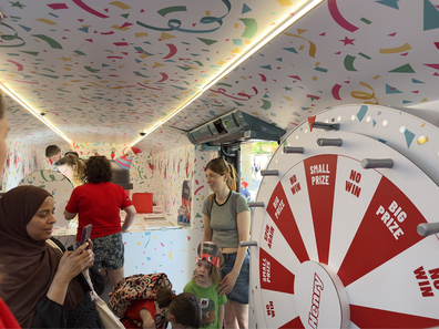 A group of guests inside the Henry promotional bus event, with a spin-to-win game for the brand's anniversary.