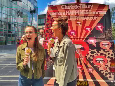 Two women laugh at the brand activation for Charlotte Tilbury.