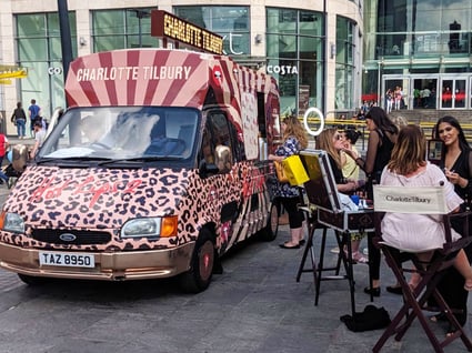 An ice cream van used for beauty pop-ups, this time with a crowd of women getting their makeup applied.