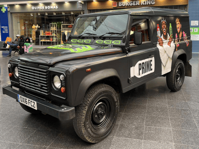 A black Land Rover Defender, branded for PRIME's product sampling campaign.