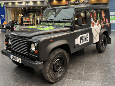 A Land Rover Defender in London near Burger King, with KSI on the side for the brand Prime.