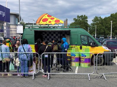 The modern sampling van for TMNT, with a 3D pizza slice and crowd nearby