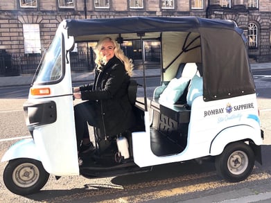 A blonde woman drives the Bombay Sapphire branded tuk tuk hire