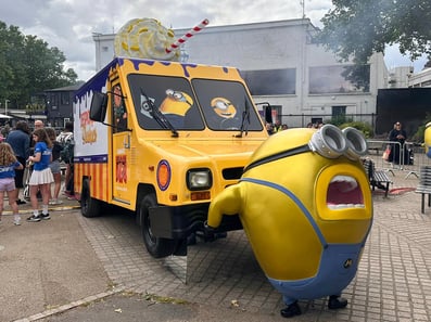 A Utilimaster mail truck, held aloft by a Minion for Despicable Me for Universal, branded and delivered by Promohire.