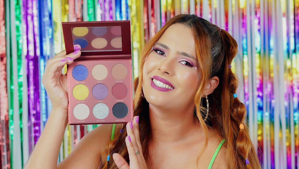 A woman smiles with a makeup compact for a colourful experiential marketing event.
