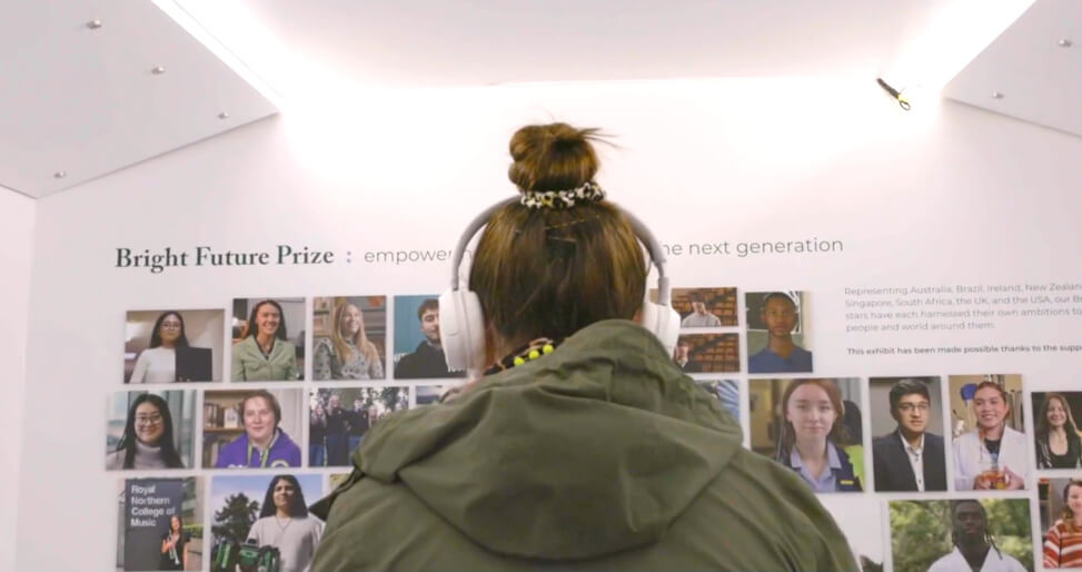 A woman enjoys an interactive space, with headphones on, at the ACT Ardonagh Group exhibition tour.