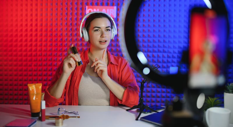 A beauty brand influencer talks through makeup on her podcast.