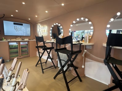 Seating and a TV screen in the Beauty Works vintage Airstream.