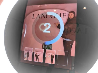 A woman waits for the Promohire photo booth to snap a picture at the Lancome activation.