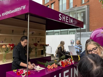 A woman prepares flowers at the SHEIN Goes With Everything promotional pop-up event.