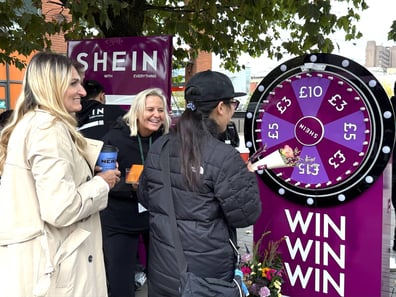 A crowd enjoys a game to win prizes at SHEIN's pop-up event, with build work from Promohire.