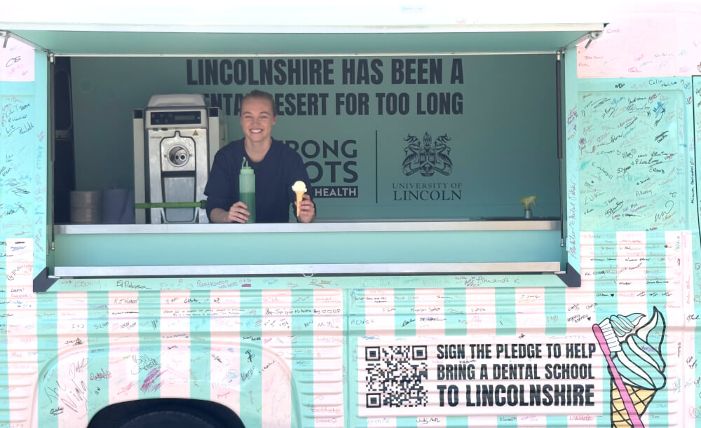 The University of Lincoln Strong Roots for Oral Health van, with signatures and a young woman holding an ice cream.