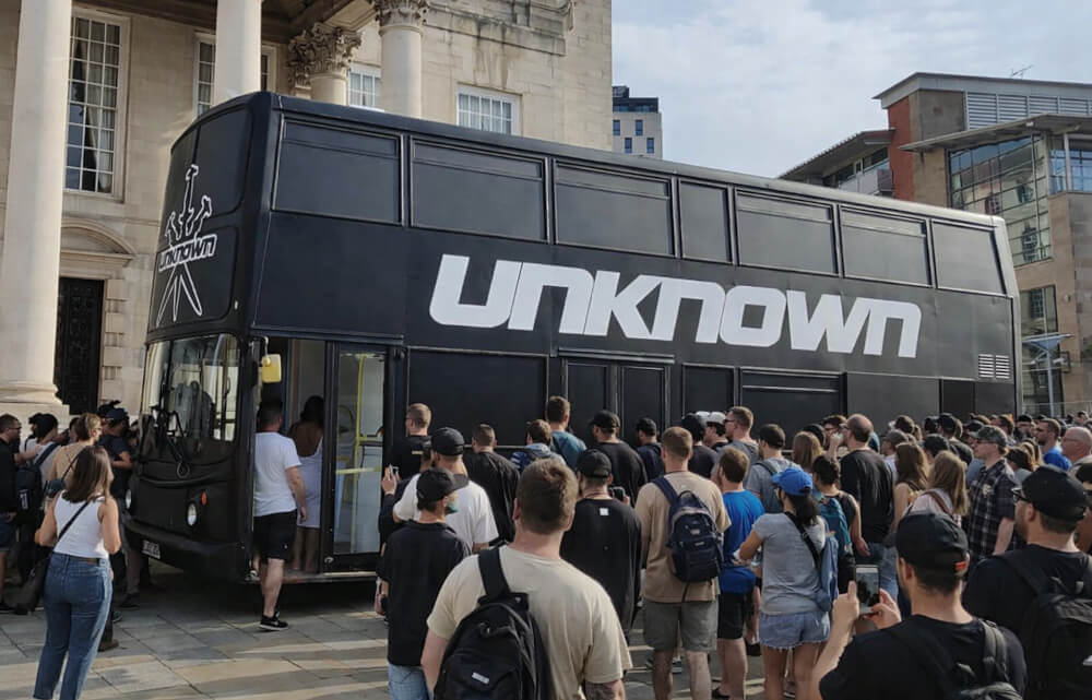 A crowd gathers at the Unknown Bus during one of their experiential events.
