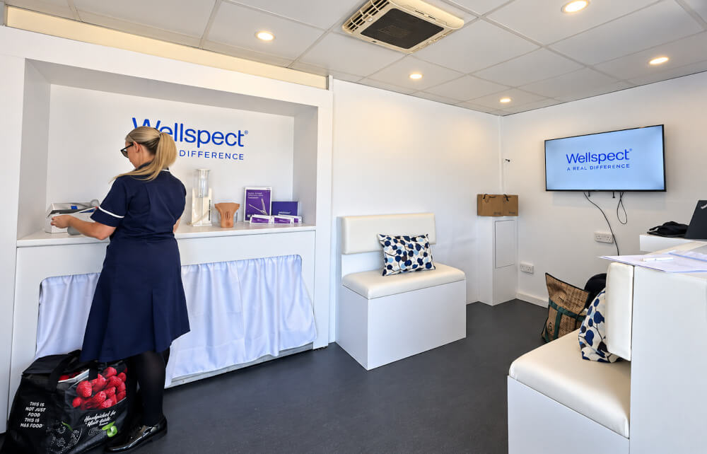 A nurse inside the Wellspect and NHS exhibition vehicle, preparing for a training course.