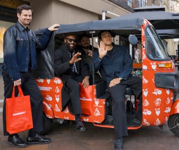 The founder of Born to Stand Out and his team in a promotional tuk tuk - one of the brand's influencer campaign ideas for their UK launch.