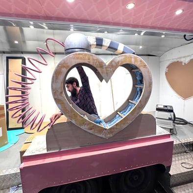 A Promohire team member builds the Charlotte Tilbury gamification element - a pink heart phone prop.