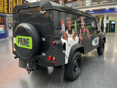 A rear view of Prime's custom Land Rover Defender in London train station for a brand event or activation.