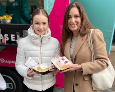 A mother and daughter holding free sticky buns as the E.L.F. live experience.