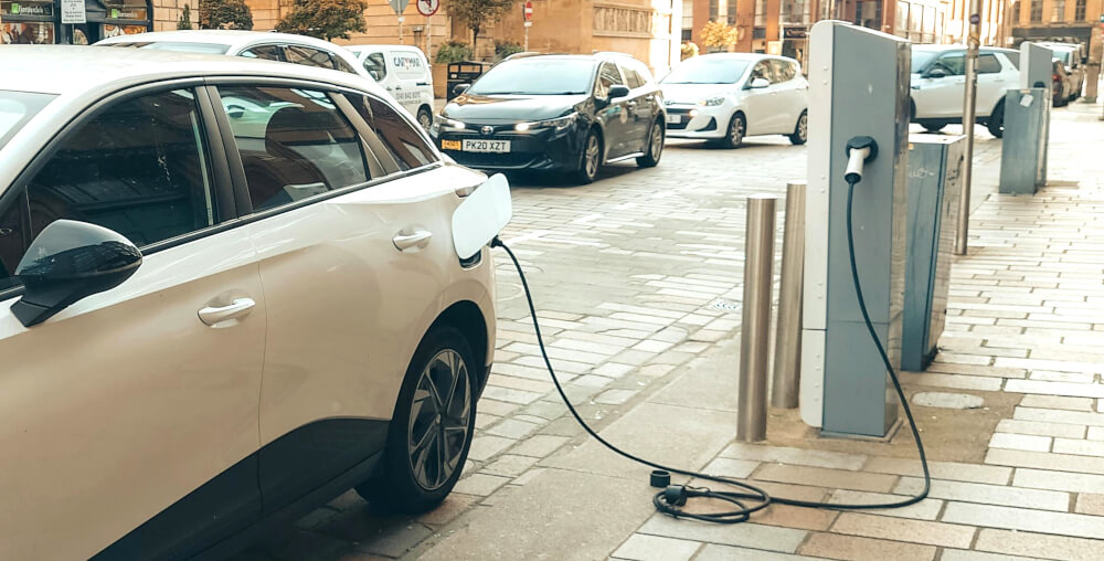 An electric hire vehicle on the street, being charged