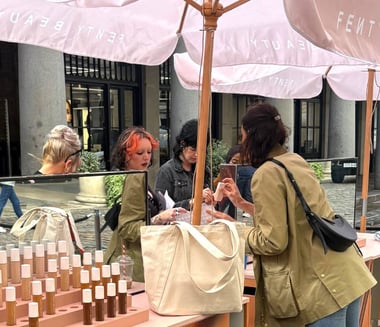 Women try foundation samples at Fenty's live event.