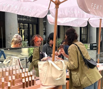 Women try out FENTY Beauty's free foundations at a London event.