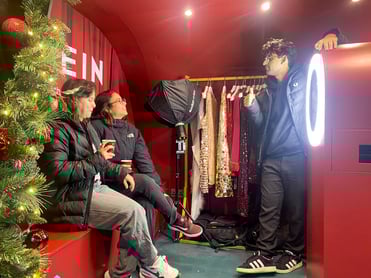 Three people relax at the photo kiosk at SHEIN's festive event.