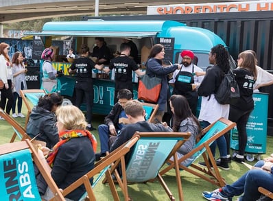 A crowd sits around a Renault Estafette, with Tony Singh MBE, for Listerine's food and drink sampling event.