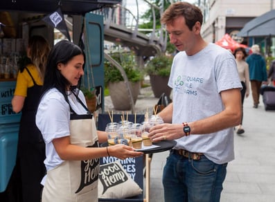 Good Hemp staff hands out free drinks at their brand awareness campaign, with sampling.
