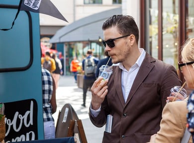 A student enjoys a drink at a sampling brand experience.