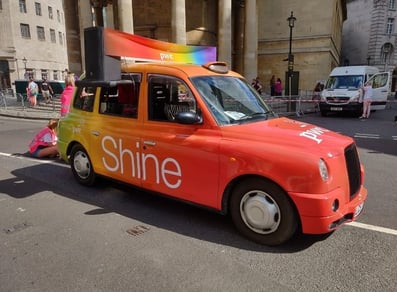 The Shine taxi rental, driving on a city street.