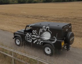 black land rover defender with solar panels