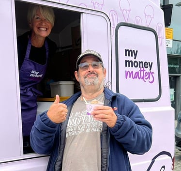 A guest holding on of the My Money Matters ice cream samples, with a happy server behind him.