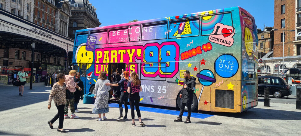 A double-decker bus hire in a city centre, near a railway station