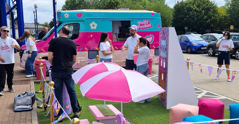 A crowd gathers for Polly Pocket's brand campaign ice cream van, with a photo ops and seating area.