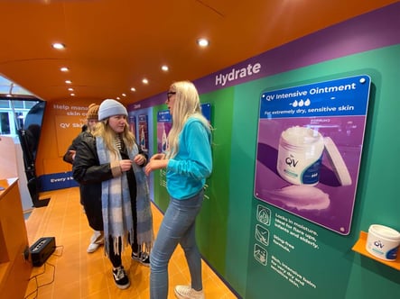 Staff engage with guests inside QV Skincare's beauty campaign Airstream vehicle.