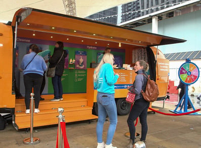 Guests learn about QV Skincare at the custom event Airstream trailer.