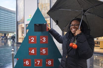 An influencer smiles with an event prop and umbrella.