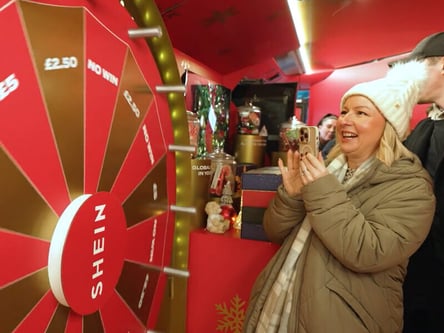 A blonde woman tries the spin-to-win game at SHEIN's Christmas campaign.