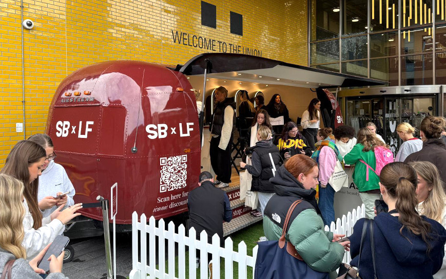 Students gather at LookFantastic's beauty marketing event, waiting for their free makeovers.