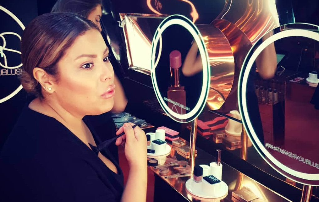 An image of a woman with a make-up brush in the NARS beauty event Airstream.