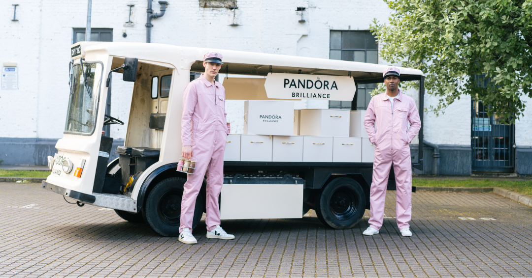 The white 'Pandora' electric milk float hire, with brand ambassadors posing in pink jumpsuits.
