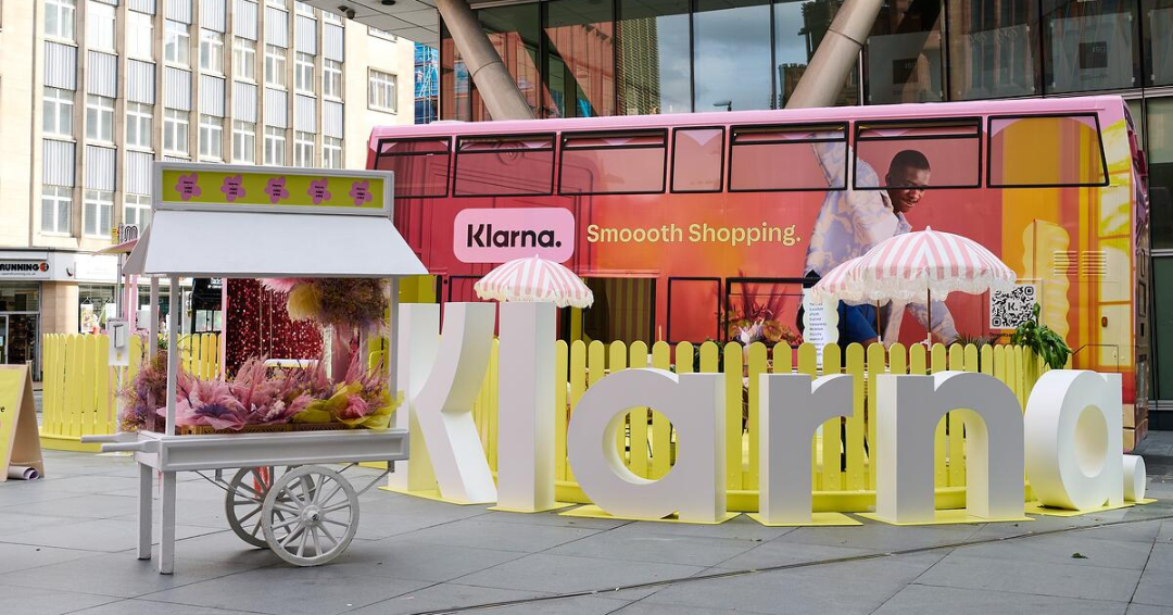 The Klarna campaign vehicle, parked behind a giant branded sign for a live promotion.